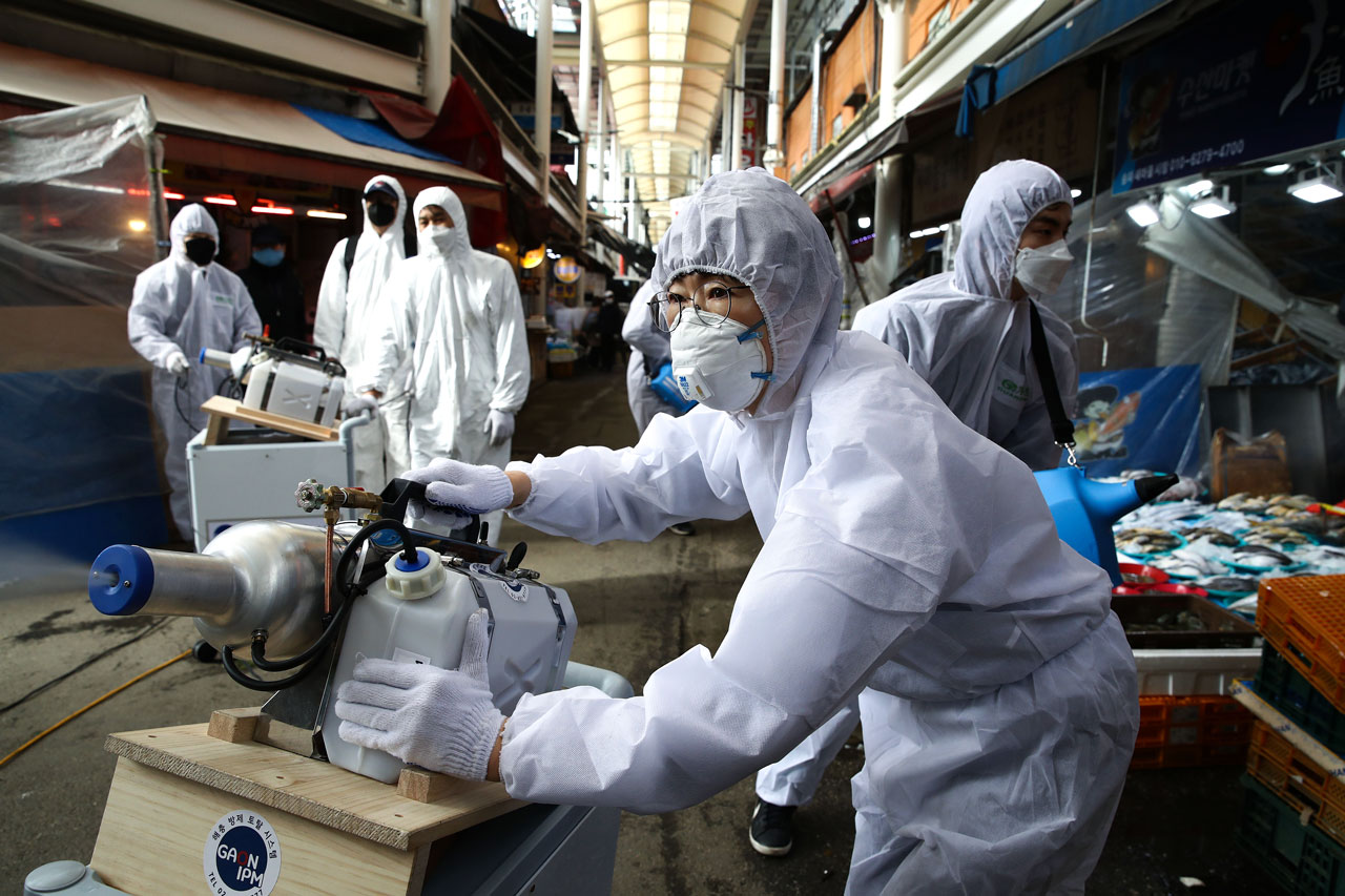 26 FEBRUARY  As the number of confirmed cases rises, workers spray disinfectant solution at a traditional market in Seoul.