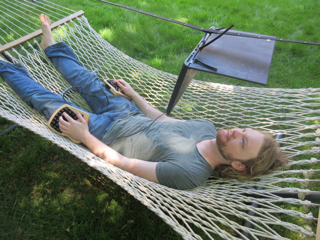 Michael Sloan in hammock, using computer