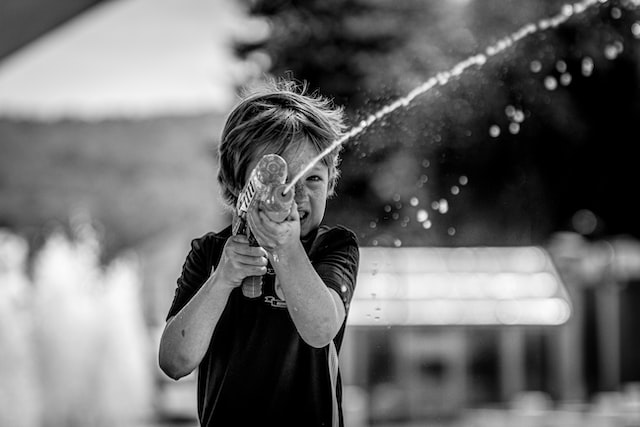 a child shooting a water pistol